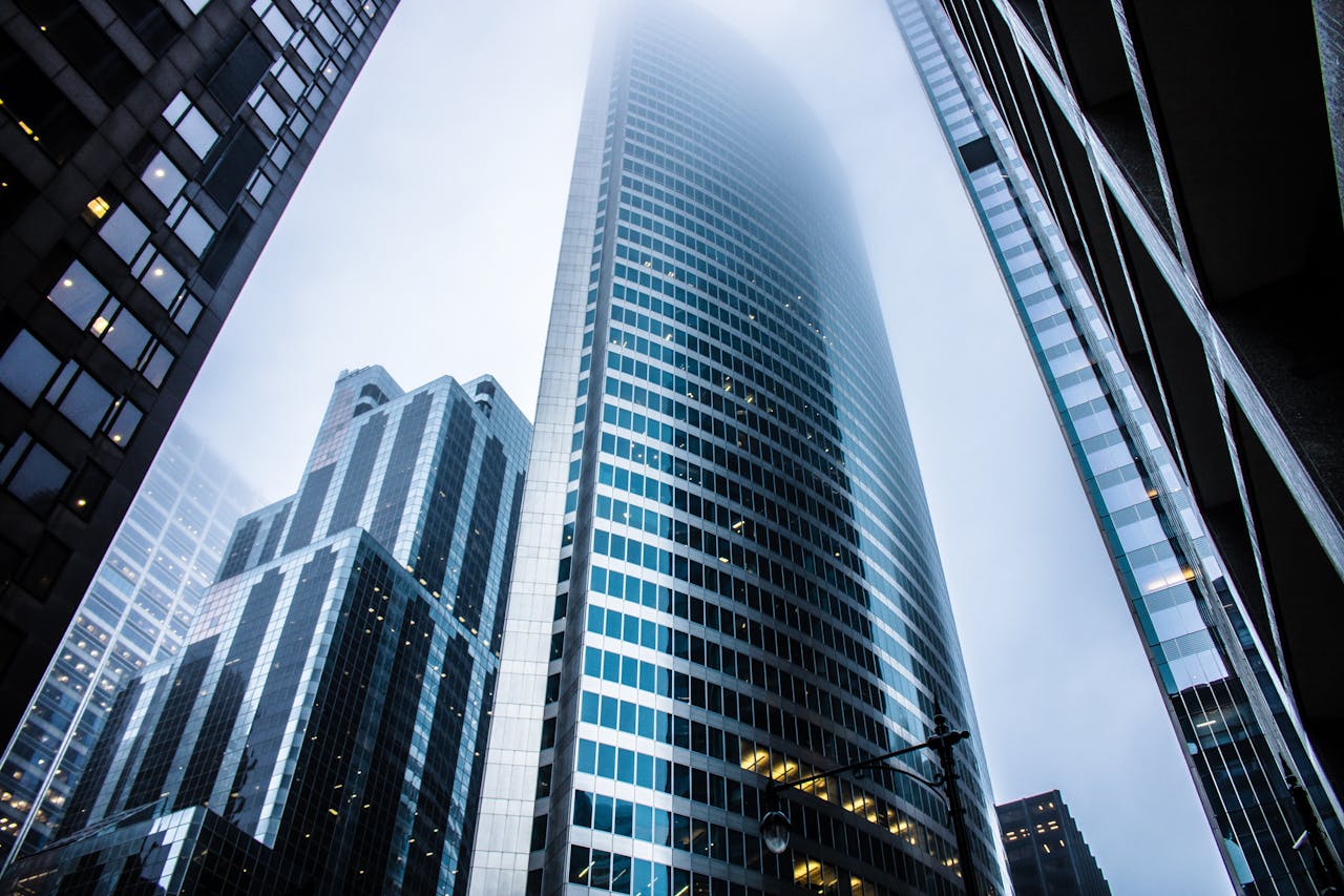 services-03 Dramatic view of modern skyscrapers shrouded in fog in an urban cityscape.